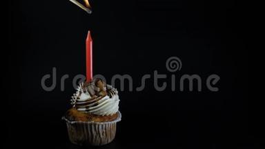 生日会盛宴庆祝理念.. 一个黑蜡烛的纸杯蛋糕。 点燃蜡烛。 代表一个理想